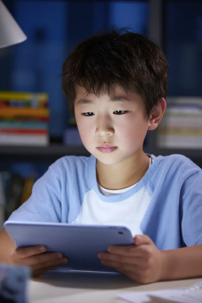 An 8-year-old boy having screen time on an electronic device