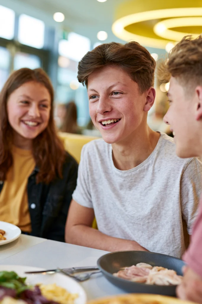 Three teenagers chatting in a restaurant