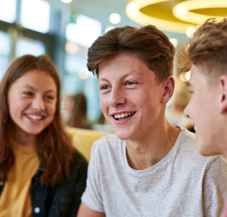 Three teenagers chatting in a restaurant