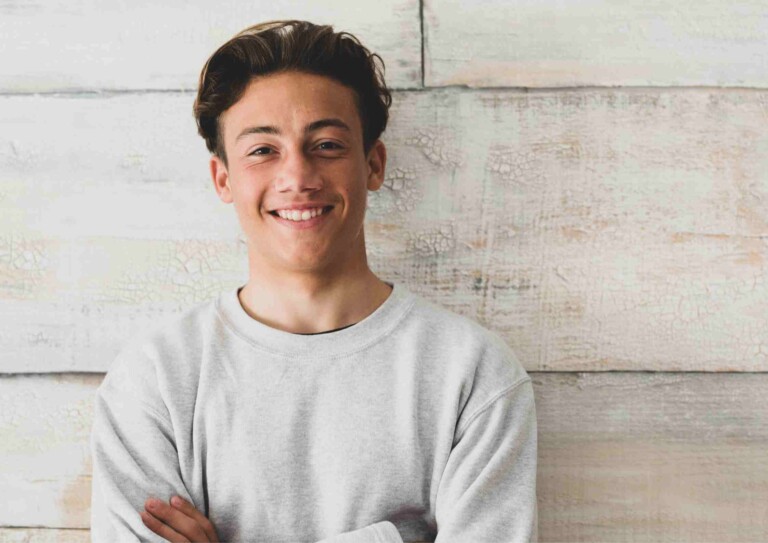 teenage boy folded arms smiling