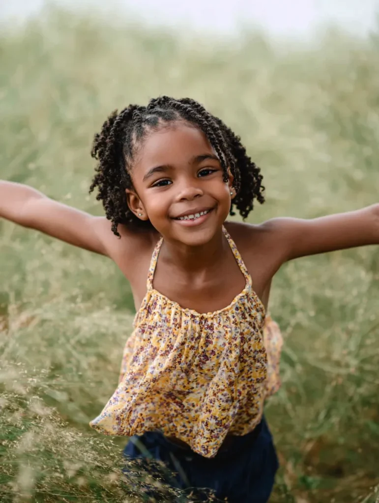 a happy little girl in a field of long grass
