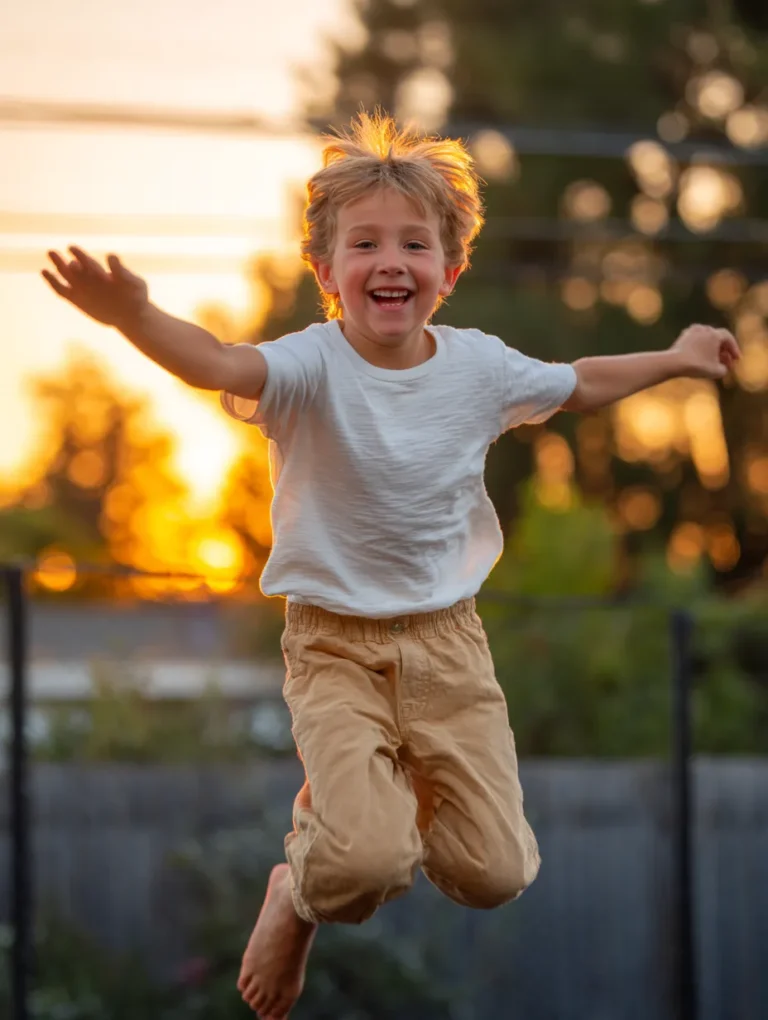a young boy happily bouncing on a trampoline