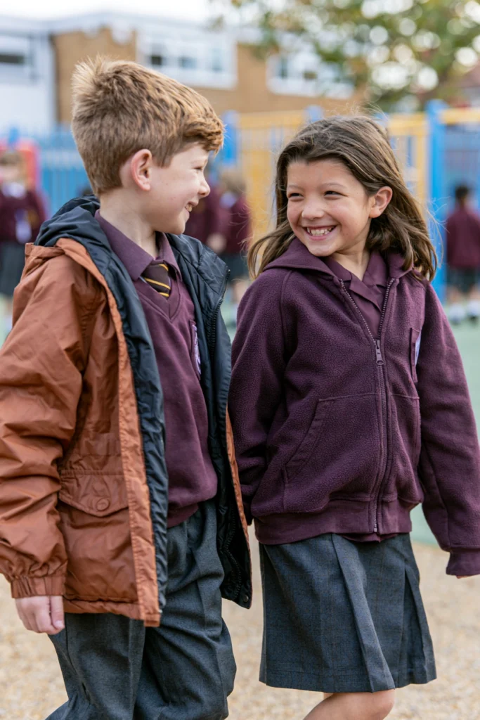 Nine-year-old school children chatting as they walk around the playground