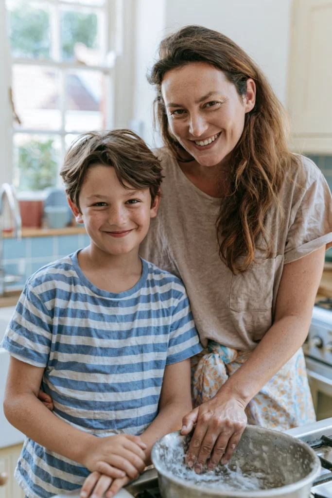 A mother and son, together in their kitchen, with a baking bowl next to them