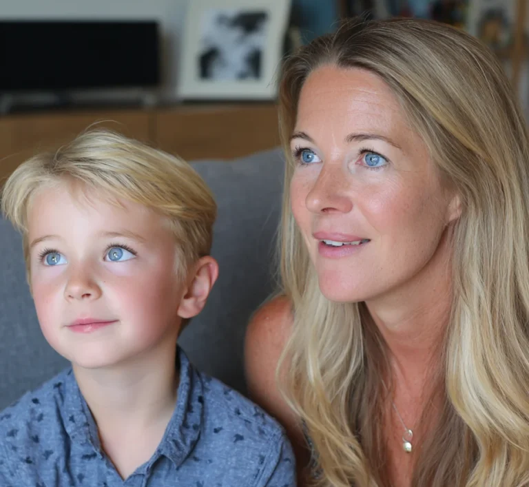 A 7-year-old boy and his mother sitting together on the sofa