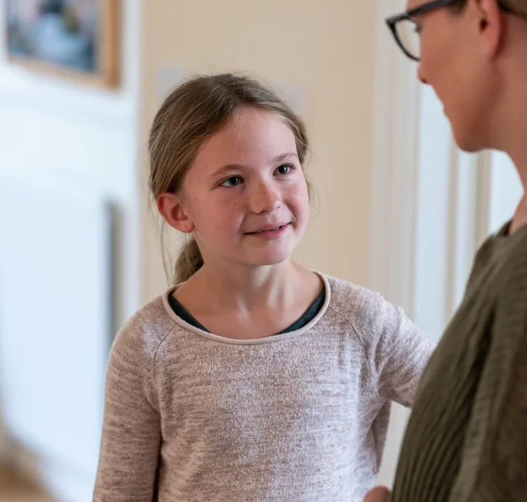 A mother and 9-year-old daughter having a face-to-face conversation and using eye contact